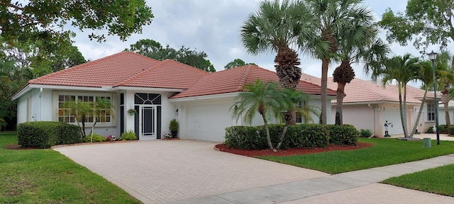 9132 Bay Harbour Cir, West Palm Beach, FL 33411 - view of front of property featuring decorative driveway, an attached garage, a tile roof, a front lawn, and stucco siding