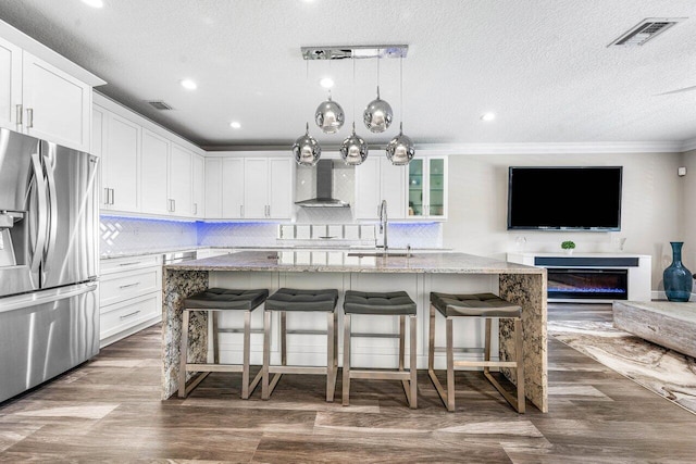9961 Marsala Way, Delray Beach, FL 33446 - kitchen featuring stainless steel fridge with ice dispenser, a sink, wall chimney exhaust hood, light stone countertops, and backsplash