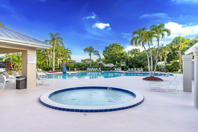 2608 SW Greenwich Way, Palm City, FL 34990 - community pool with a patio area and view of wooded area