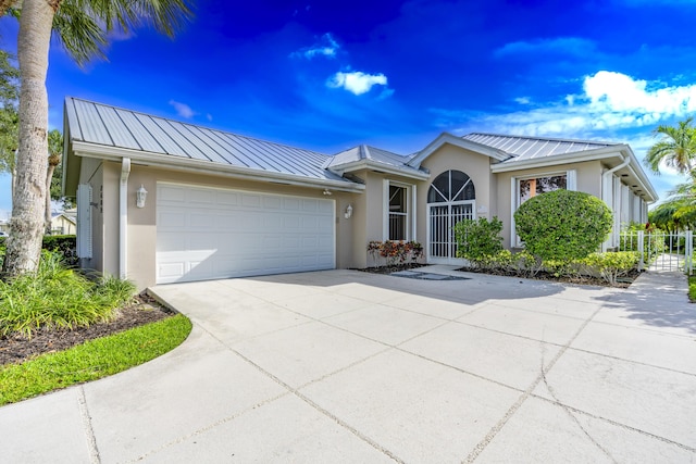 2608 SW Greenwich Way, Palm City, FL 34990 - ranch-style house with stucco siding, a standing seam roof, a metal roof, and an attached garage