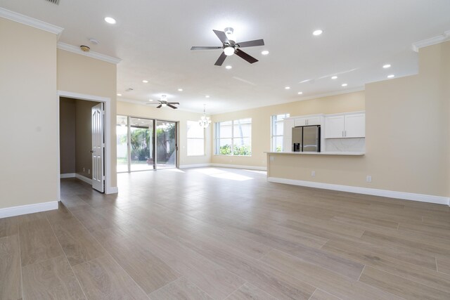 2608 SW Greenwich Way, Palm City, FL 34990 - unfurnished living room with a ceiling fan, crown molding, recessed lighting, a chandelier, and light wood-style flooring