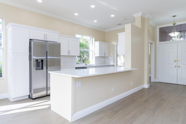 2608 SW Greenwich Way, Palm City, FL 34990 - kitchen featuring stainless steel refrigerator with ice dispenser, ornamental molding, decorative backsplash, light wood finished floors, and light countertops