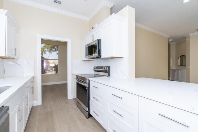 2608 SW Greenwich Way, Palm City, FL 34990 - kitchen featuring appliances with stainless steel finishes, light stone counters, white cabinetry, ornamental molding, and light wood finished floors