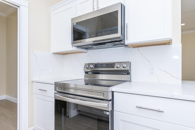 2608 SW Greenwich Way, Palm City, FL 34990 - kitchen featuring stainless steel appliances, ornamental molding, and white cabinetry