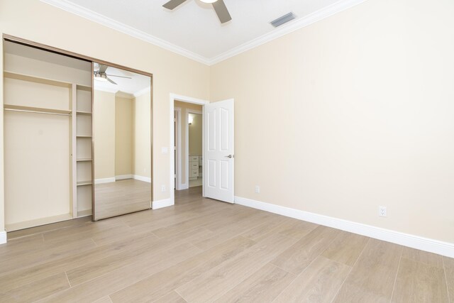 2608 SW Greenwich Way, Palm City, FL 34990 - unfurnished bedroom with ornamental molding, light wood-type flooring, a ceiling fan, and a closet