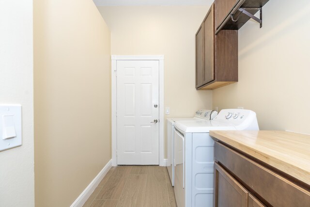 2608 SW Greenwich Way, Palm City, FL 34990 - laundry room with cabinet space, washing machine and clothes dryer, and light wood-style flooring