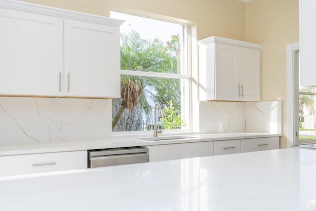 2608 SW Greenwich Way, Palm City, FL 34990 - kitchen featuring light countertops, dishwasher, white cabinetry, and backsplash