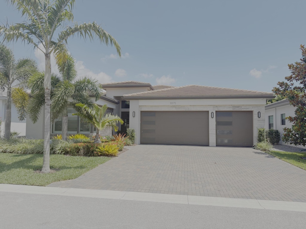 8575 Dearborn River Way, Boca Raton, FL 33496 - view of front of home featuring decorative driveway, an attached garage, and stucco siding