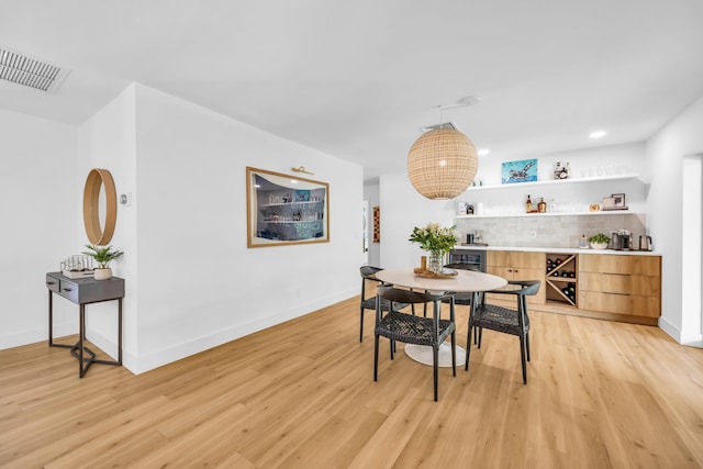 354 Country Club Dr, Tequesta, FL 33469 - dining space with a bar, light wood-type flooring, and baseboards