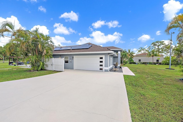 13595 89th Pl N, West Palm Beach, FL 33412 - view of front of house featuring roof mounted solar panels, an attached garage, concrete driveway, a gate, and stucco siding
