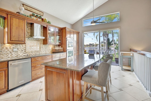1503 NW 159th Ln, Pembroke Pines, FL 33028 - kitchen with stainless steel dishwasher, wall chimney range hood, vaulted ceiling, brown cabinets, and backsplash