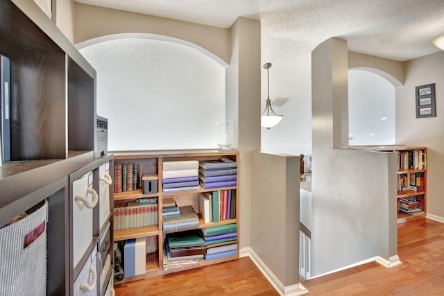 1503 NW 159th Ln, Pembroke Pines, FL 33028 - hall featuring arched walkways, wood finished floors, an upstairs landing, baseboards, and a textured ceiling