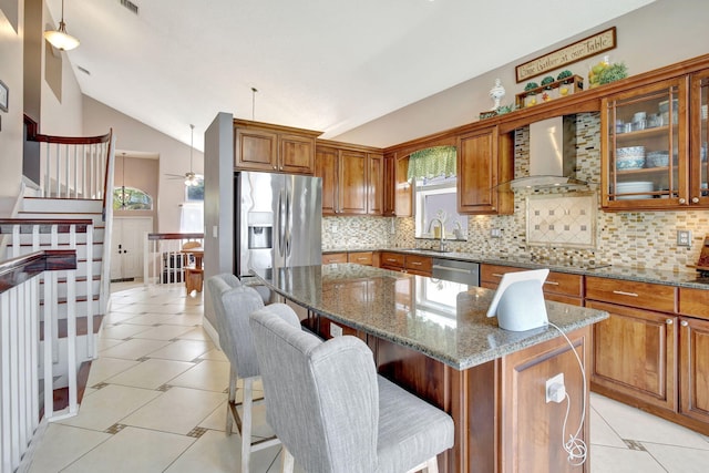 1503 NW 159th Ln, Pembroke Pines, FL 33028 - kitchen featuring wall chimney exhaust hood, stainless steel appliances, brown cabinetry, tasteful backsplash, and vaulted ceiling