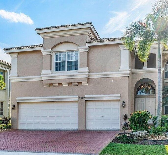 view of front of property with a garage, stucco siding, and decorative driveway