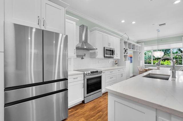 49 Lancaster Rd, Boynton Beach, FL 33426 - kitchen featuring appliances with stainless steel finishes, wall chimney range hood, ornamental molding, white cabinets, and recessed lighting