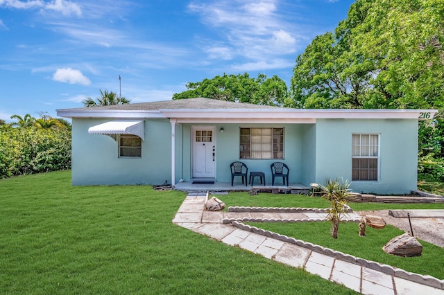 216 NE 14th St, Delray Beach, FL 33444 - view of front facade featuring covered porch, a front yard, and stucco siding