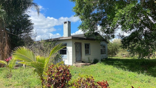 9500 Orange Ave, Fort Pierce, FL 34945 - rear view of house featuring a chimney