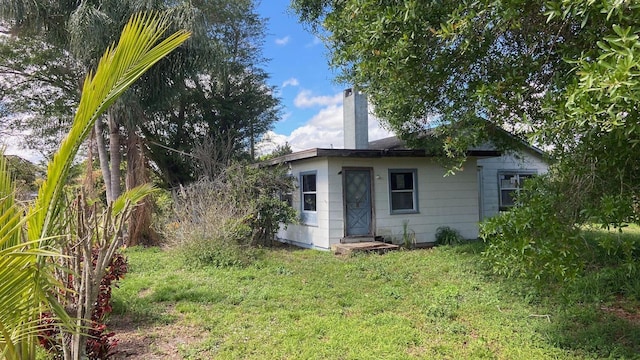 9500 Orange Ave, Fort Pierce, FL 34945 - back of property with a chimney and a lawn