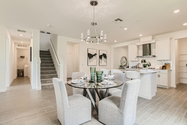 6783 Cobia Cir, Boynton Beach, FL 33437 - dining area featuring light wood-style floors, stairway, a chandelier, recessed lighting, and washer / dryer