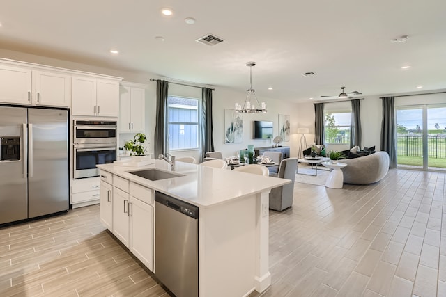 6783 Cobia Cir, Boynton Beach, FL 33437 - kitchen with stainless steel appliances, open floor plan, a chandelier, light wood-style floors, and light countertops