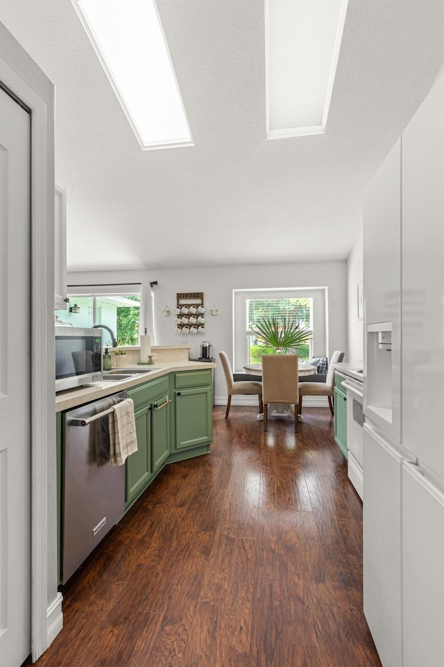 1262 SW Hunnicut Ave, Port Saint Lucie, FL 34953 - kitchen featuring green cabinets, appliances with stainless steel finishes, dark wood finished floors, and plenty of natural light