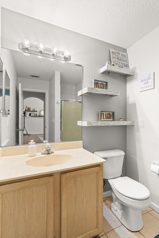 1262 SW Hunnicut Ave, Port Saint Lucie, FL 34953 - bathroom with tile patterned floors, toilet, a stall shower, vanity, and a textured ceiling