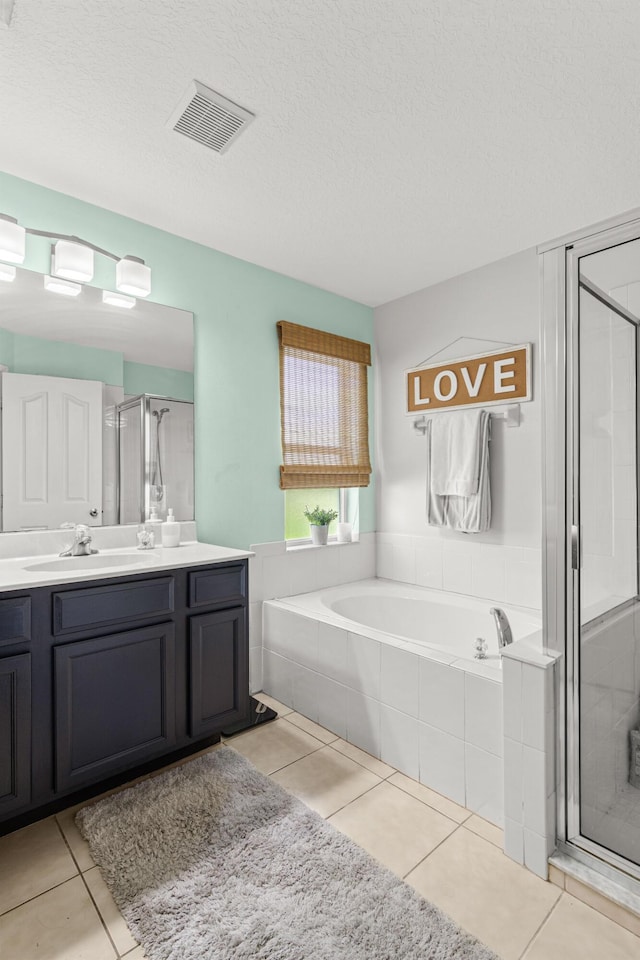 1262 SW Hunnicut Ave, Port Saint Lucie, FL 34953 - bathroom with vanity, a shower stall, a garden tub, tile patterned flooring, and a textured ceiling