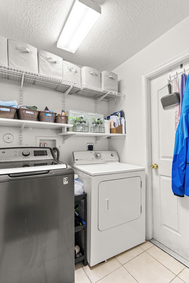 1262 SW Hunnicut Ave, Port Saint Lucie, FL 34953 - laundry area featuring washer and clothes dryer, a textured ceiling, and light tile patterned flooring