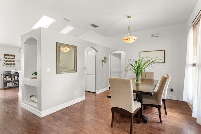 1262 SW Hunnicut Ave, Port Saint Lucie, FL 34953 - dining room featuring dark wood-type flooring, baseboards, arched walkways, and a skylight