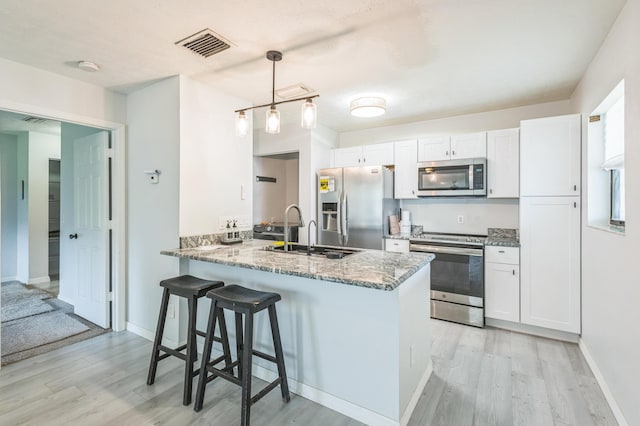 6537 SE Federal Hwy Unit 202, Stuart, FL 34997 - kitchen featuring stainless steel appliances, a sink, light wood-style floors, and white cabinetry