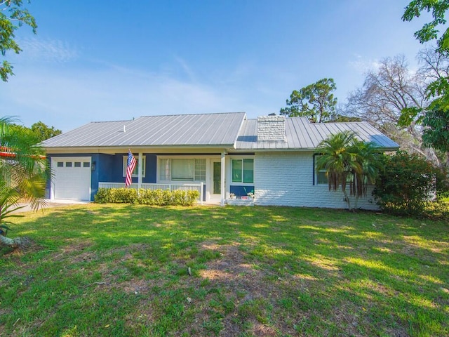3416 Atlantic Blvd, Vero Beach, FL 32960 - view of front of home featuring an attached garage, a front lawn, metal roof, and brick siding