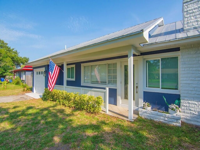 3416 Atlantic Blvd, Vero Beach, FL 32960 - view of front facade featuring a garage, covered porch, driveway, a front lawn, and metal roof