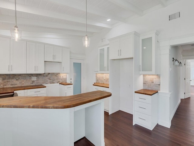 3416 Atlantic Blvd, Vero Beach, FL 32960 - kitchen featuring butcher block counters, decorative backsplash, dark wood-type flooring, glass insert cabinets, and white cabinets