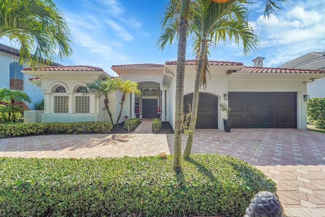 5036 NW 24th Cir, Boca Raton, FL 33431 - mediterranean / spanish home with an attached garage, decorative driveway, stucco siding, and a tile roof