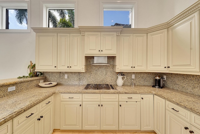 5036 NW 24th Cir, Boca Raton, FL 33431 - kitchen featuring stainless steel gas stovetop, decorative backsplash, wall chimney range hood, and light stone countertops