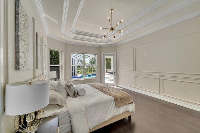 5036 NW 24th Cir, Boca Raton, FL 33431 - bedroom featuring crown molding, a chandelier, a decorative wall, dark wood-style flooring, and a tray ceiling