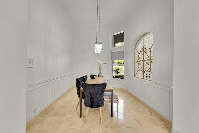 5036 NW 24th Cir, Boca Raton, FL 33431 - dining space featuring crown molding, a decorative wall, marble finish flooring, wainscoting, and a towering ceiling