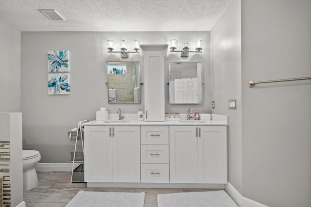 462 SW Sundance Trl, Port Saint Lucie, FL 34953 - bathroom with toilet, baseboards, double vanity, and a textured ceiling