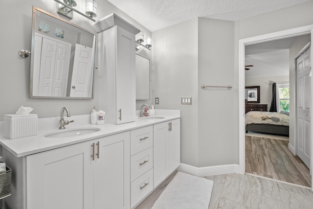 462 SW Sundance Trl, Port Saint Lucie, FL 34953 - full bathroom featuring double vanity, ensuite bathroom, a textured ceiling, and baseboards