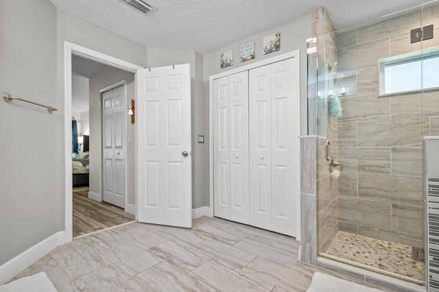 462 SW Sundance Trl, Port Saint Lucie, FL 34953 - bathroom with a closet, connected bathroom, a stall shower, baseboards, and a textured ceiling
