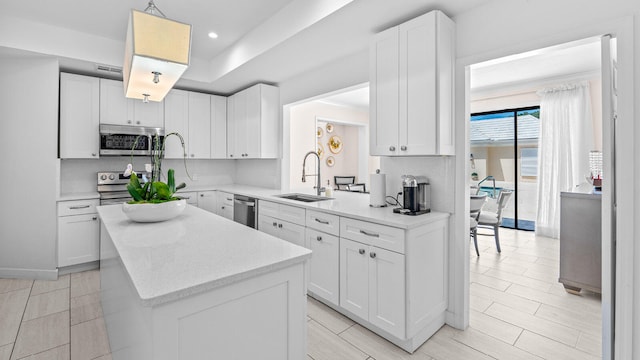 11354 Old Harbour Rd, North Palm Beach, FL 33408 - kitchen featuring appliances with stainless steel finishes, a sink, a kitchen island, white cabinets, and recessed lighting