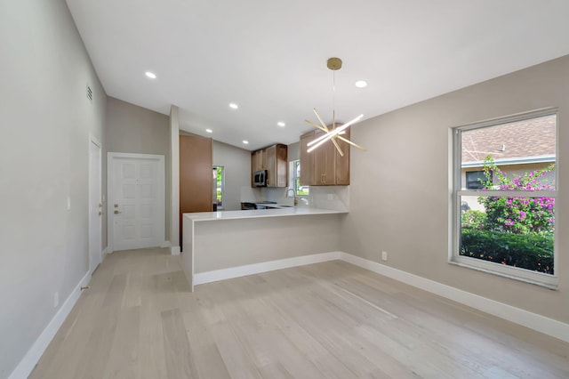 8164 Sweetbriar Way, Boca Raton, FL 33496 - kitchen with stainless steel microwave, light wood finished floors, a sink, light countertops, and baseboards