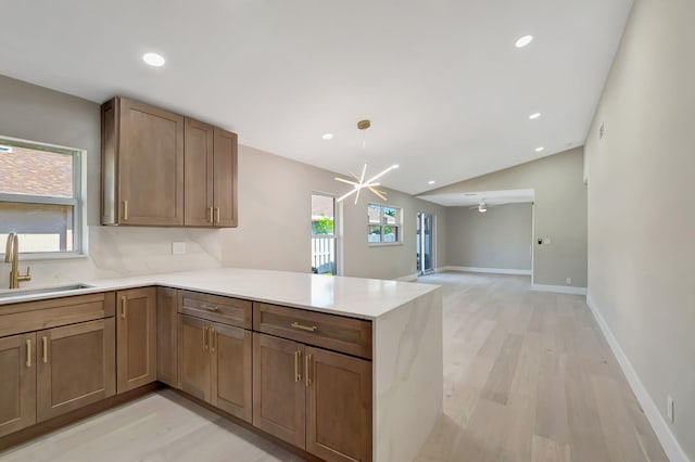 8164 Sweetbriar Way, Boca Raton, FL 33496 - kitchen featuring a peninsula, light wood-style flooring, a sink, light countertops, and baseboards