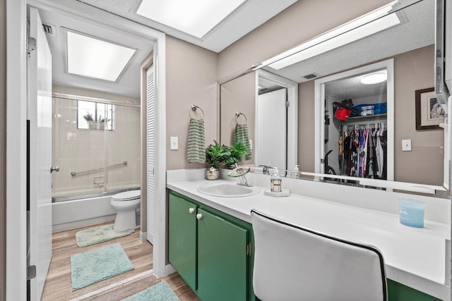 5100 Las Verdes Cir Unit 316, Delray Beach, FL 33484 - bathroom with toilet, shower / bath combination with glass door, vanity, wood finished floors, and a walk in closet