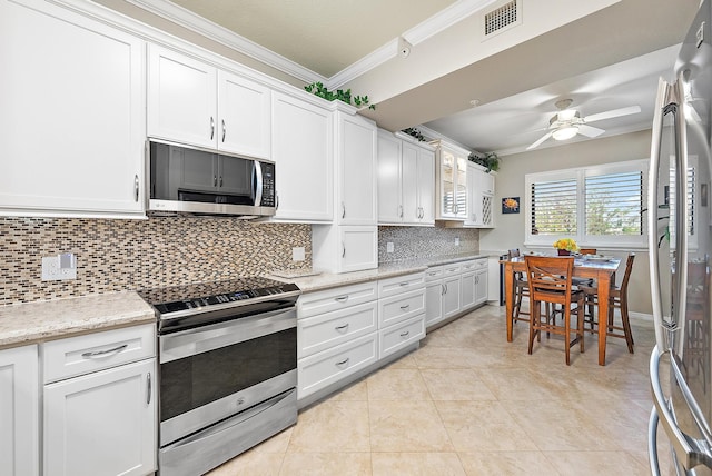 370 Golfview Rd Unit 304, North Palm Beach, FL 33408 - kitchen with appliances with stainless steel finishes, ornamental molding, a ceiling fan, decorative backsplash, and white cabinetry