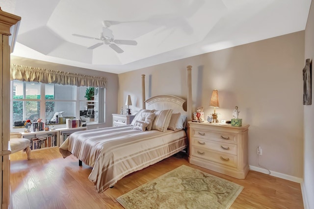 7714 Las Cruces Ct, Boynton Beach, FL 33437 - bedroom featuring a tray ceiling, light wood finished floors, a ceiling fan, and baseboards