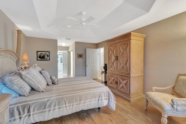 7714 Las Cruces Ct, Boynton Beach, FL 33437 - bedroom with light wood-type flooring, a raised ceiling, ceiling fan, and a textured wall