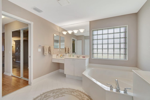 7714 Las Cruces Ct, Boynton Beach, FL 33437 - bathroom featuring a garden tub, vanity, and baseboards