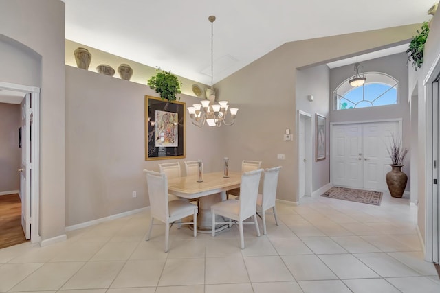 7714 Las Cruces Ct, Boynton Beach, FL 33437 - dining area with vaulted ceiling, a chandelier, light tile patterned floors, and baseboards