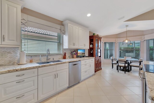 7714 Las Cruces Ct, Boynton Beach, FL 33437 - kitchen with stainless steel dishwasher, a sink, decorative backsplash, vaulted ceiling, and white cabinetry